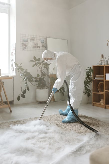 A woman performs surface cleaning of a patterned area rug in a living room with wooden flooring, using a yellow vacuum cleaner. The room features a brown leather sofa positioned adjacent to the rug, w